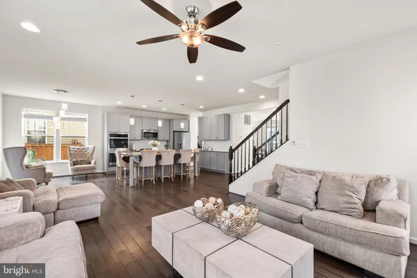 a living room with furniture kitchen view and a chandelier