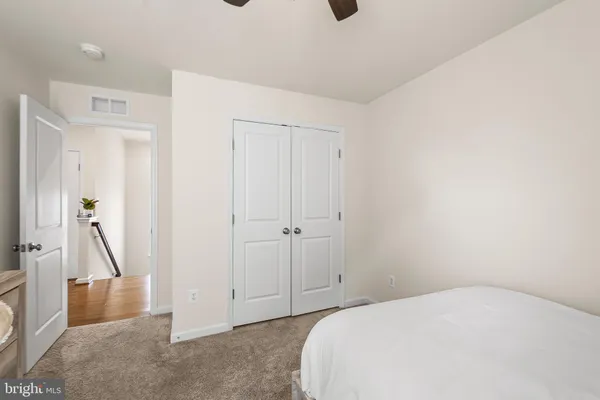 a bedroom with a bed and a view of living room