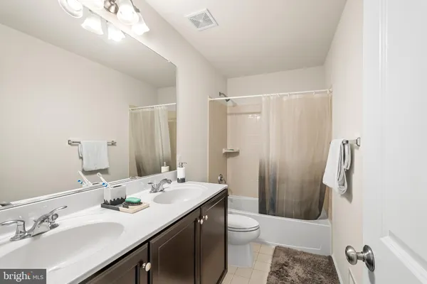 a bathroom with a sink a toilet a mirror and shower