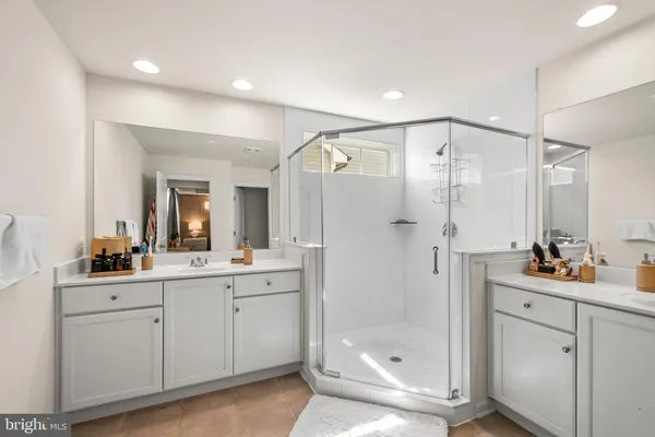 a bathroom with a double vanity sink mirror and shower