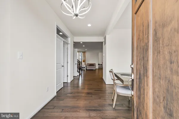 a view of a hallway with wooden floor and a chandelier