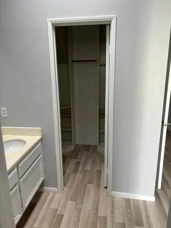 a view of walk in closet with wooden floor