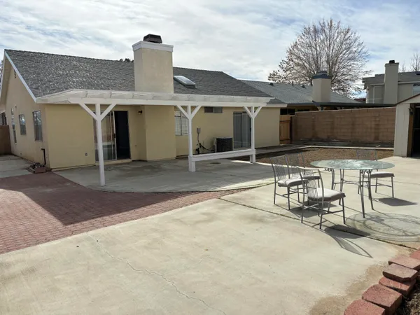 a view of a patio with table and chairs a barbeque with wooden fence