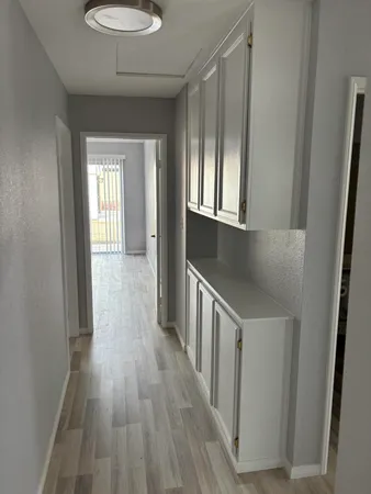 a hallway with wooden floor windows
