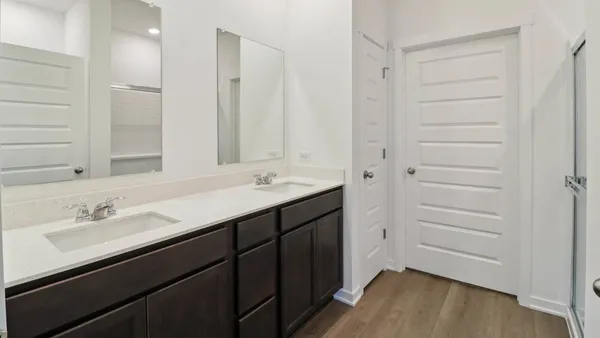 a bathroom with a double vanity sink a mirror and a shower