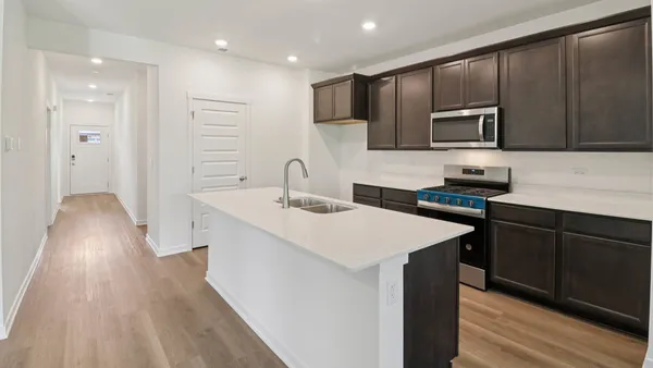 a kitchen with a sink a microwave and cabinets