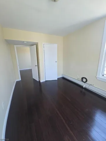 a view of a room with wooden floor and white walls