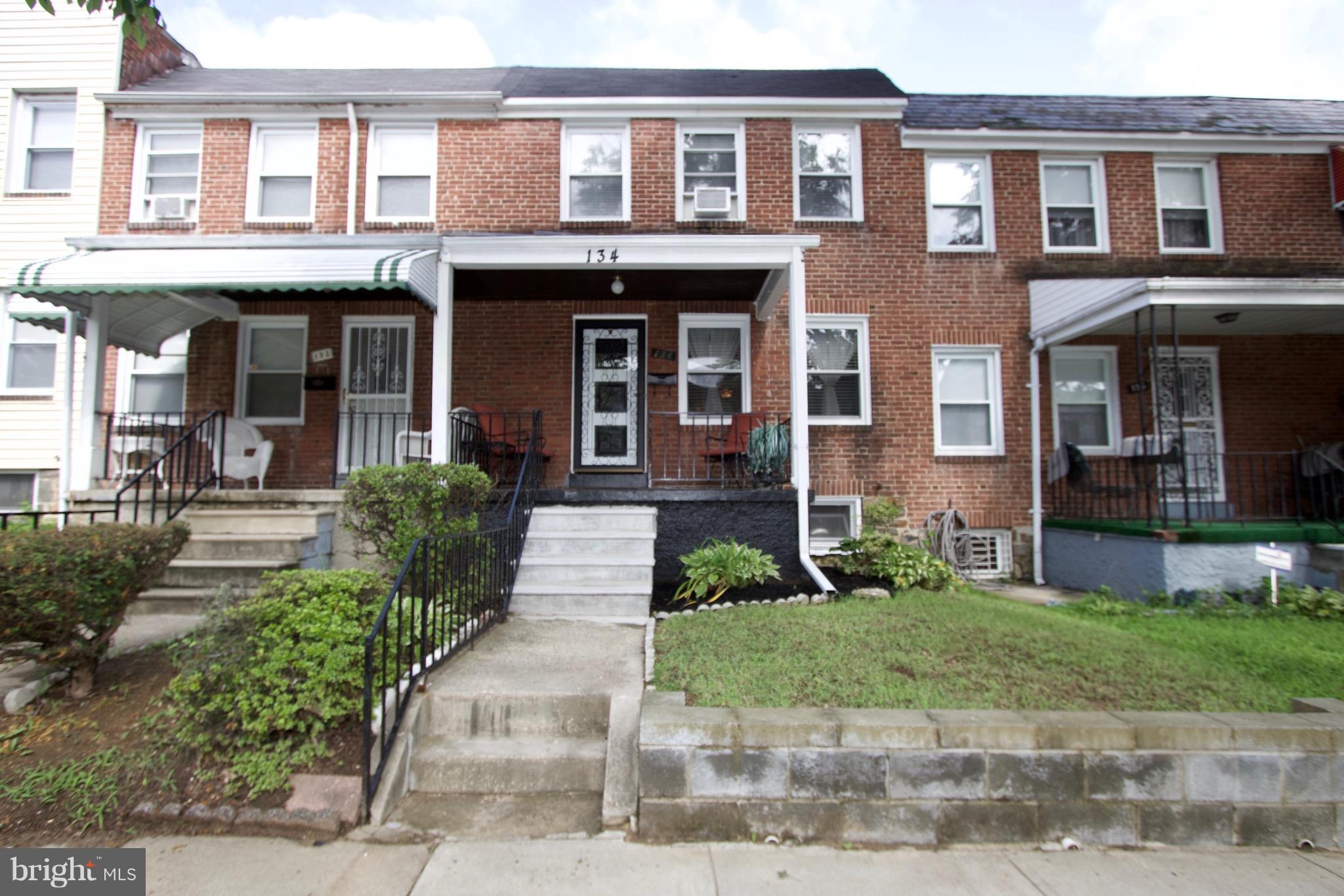 134 North Culver Street Baltimore, MD 21229 - Photo 2 of 30 a front view of a brick house with a yard