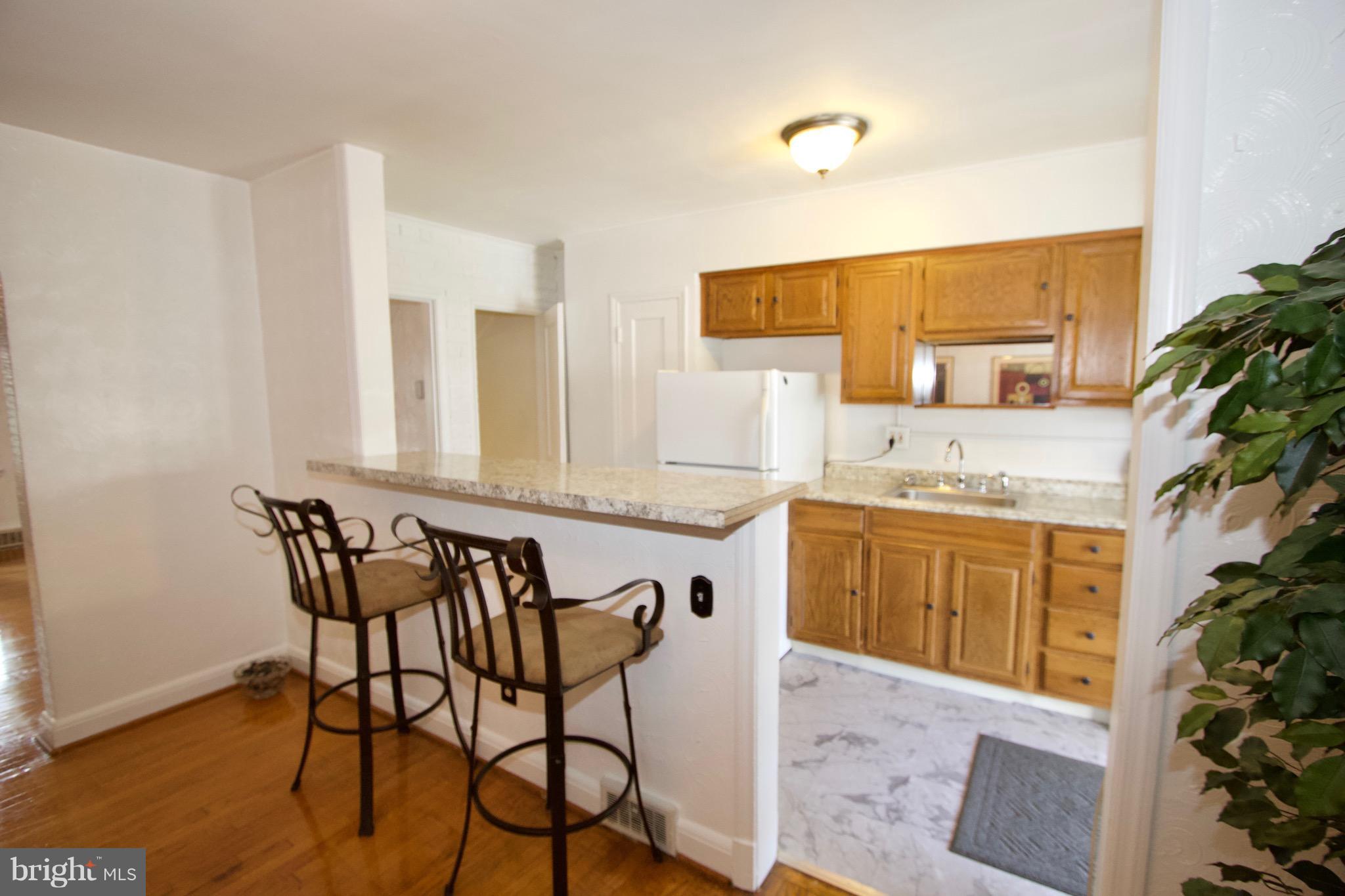 134 North Culver Street Baltimore, MD 21229 - Photo 12 of 30 a kitchen with a table chairs sink and cabinets