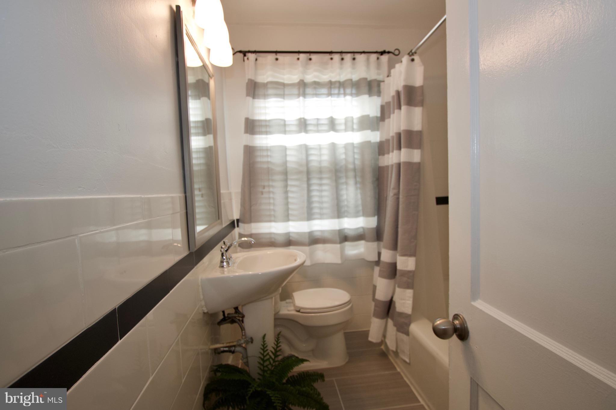 134 North Culver Street Baltimore, MD 21229 - Photo 21 of 30 a bathroom with a granite countertop bathtub shower sink vanity and toilet