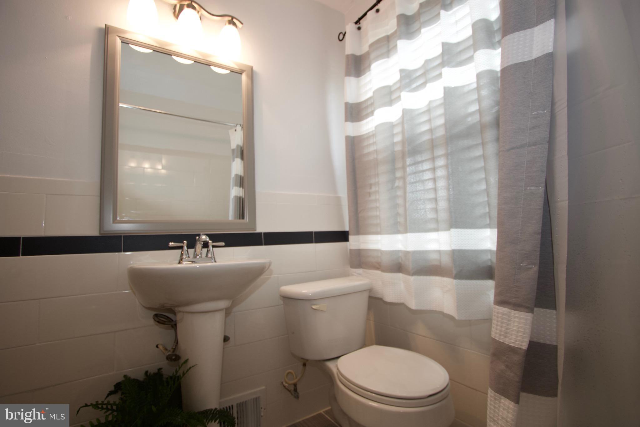 134 North Culver Street Baltimore, MD 21229 - Photo 22 of 30 a bathroom with a sink mirror toilet and shower