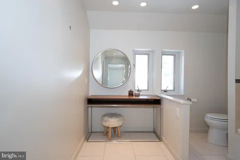a bathroom with a toilet a sink and a mirror