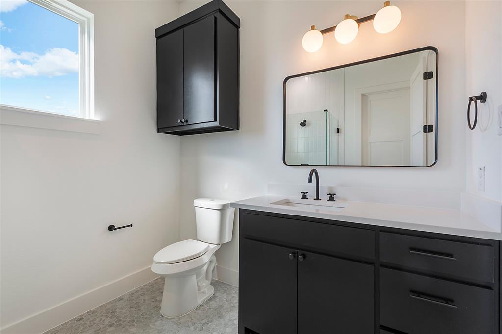 430 Whispering Way Red Oak, TX 75154 - Photo 28 of 40 Bathroom featuring a white vanity with dark cabinetry, a rectangular framed mirror, three-light vanity fixture, and a window