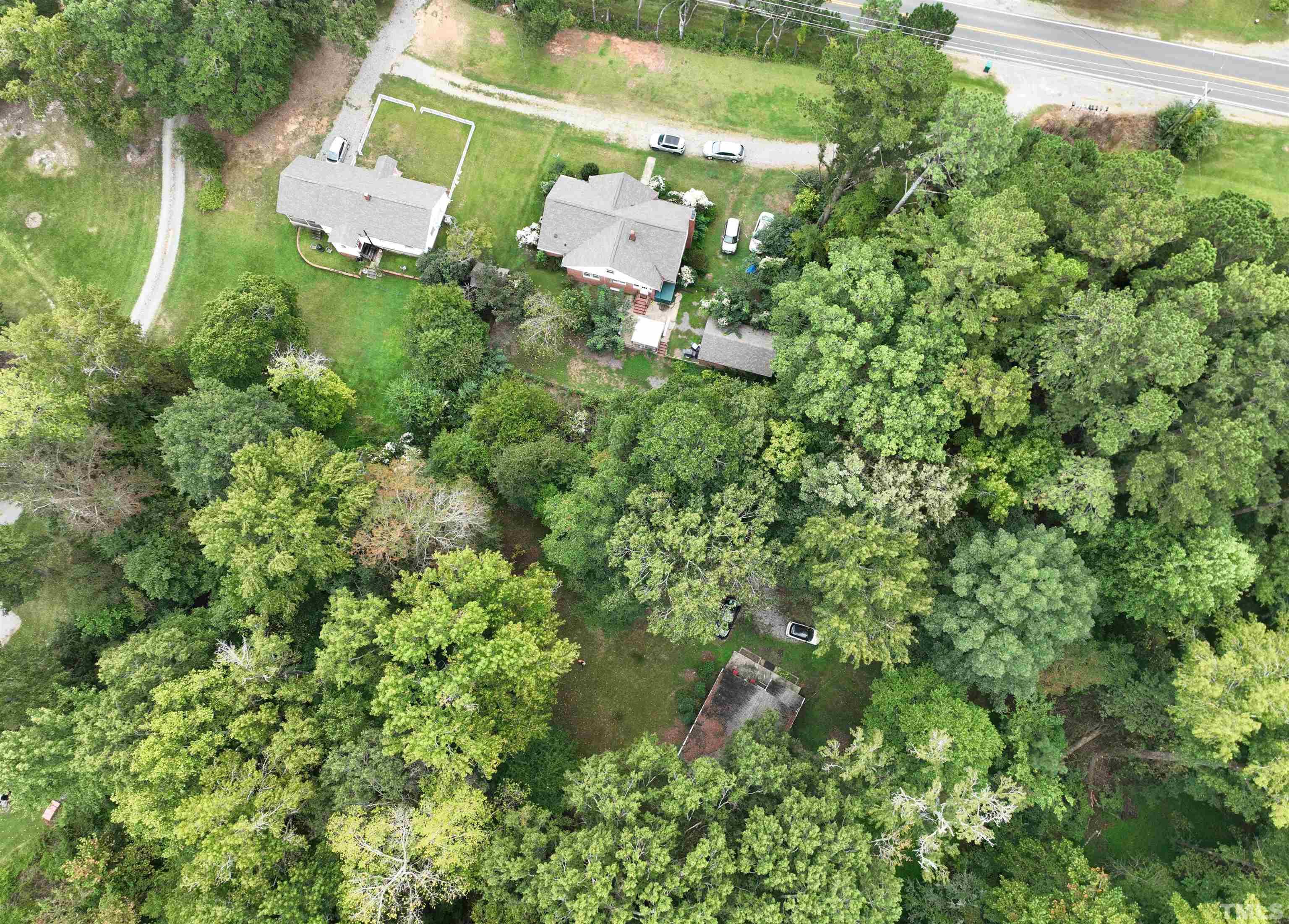 an aerial view of residential house with outdoor space and trees all around