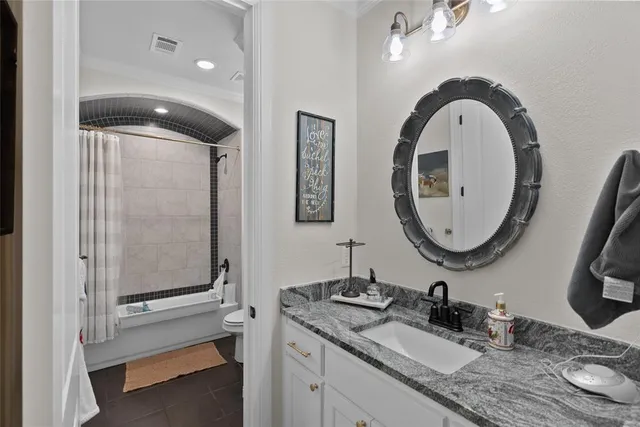 a bathroom with a granite countertop double vanity sink and a mirror