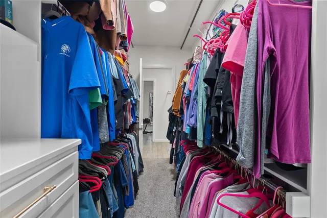 a view of walk in closet with clothes
