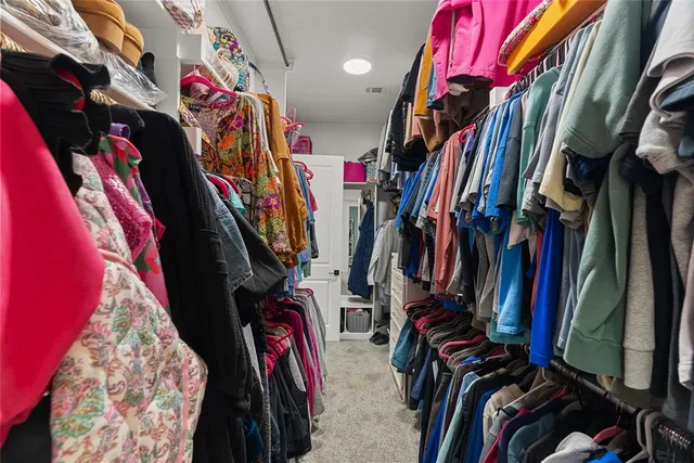 a view of walk in closet with clothes