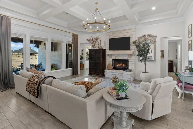 a living room with furniture a fireplace and a chandelier