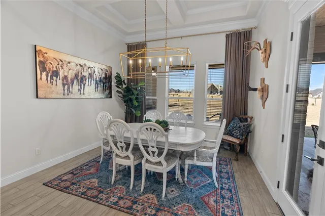 a view of a dining room with furniture a chandelier and wooden floor