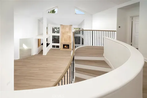 wooden floor fireplace and natural light in room