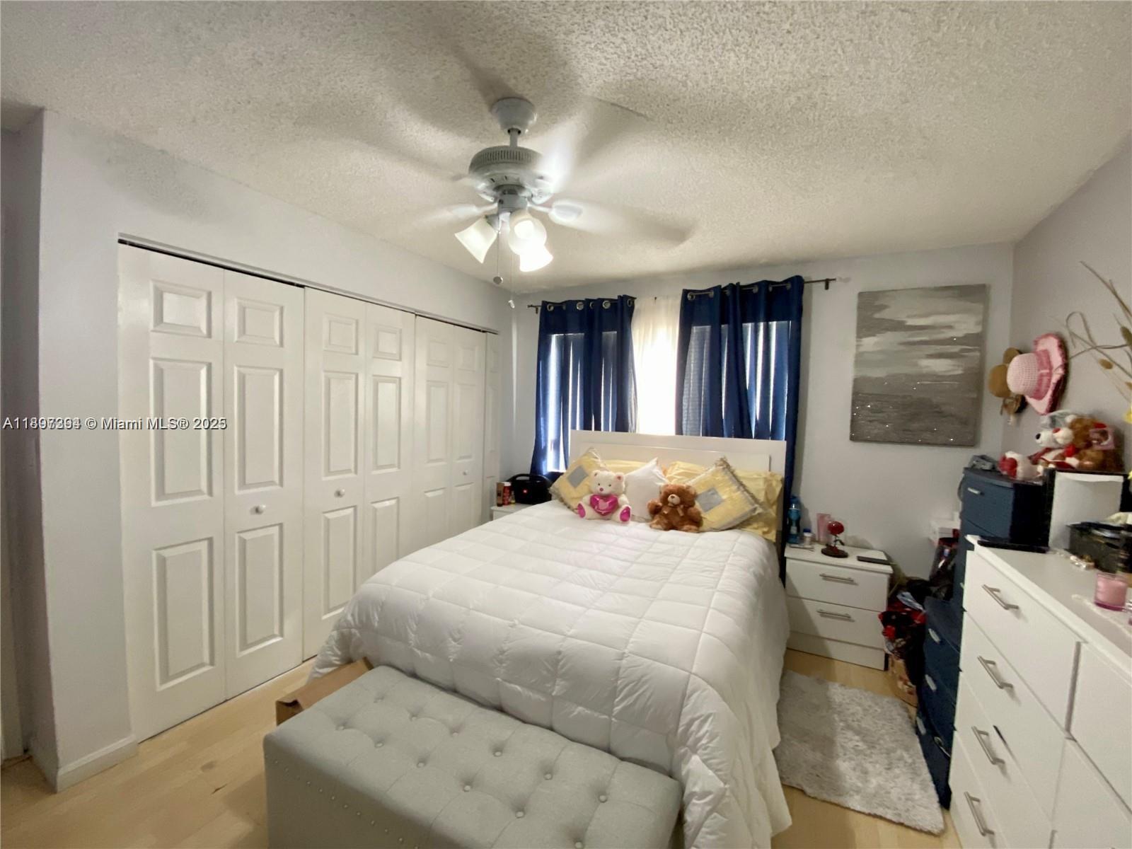 8039 Lake Drive, Unit 201 Doral, FL 33166 - Photo 7 of 9 a bedroom with a bed and a chandelier