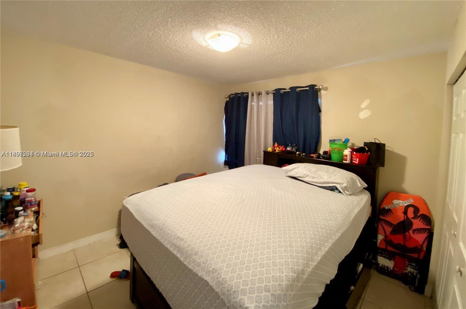 8039 Lake Drive, Unit 201 Doral, FL 33166 - Photo 8 of 9 a bedroom with a bed and a closet