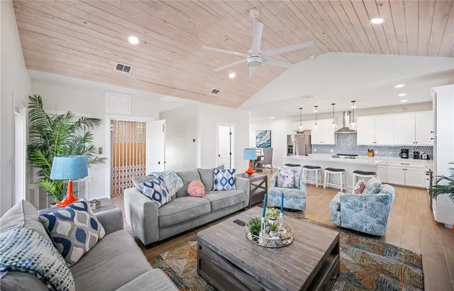 a living room with furniture and a view of kitchen