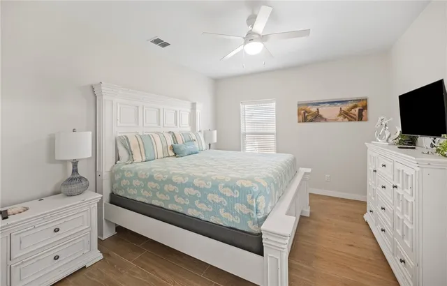 a bedroom with a large bed and a flat tv screen on dresser
