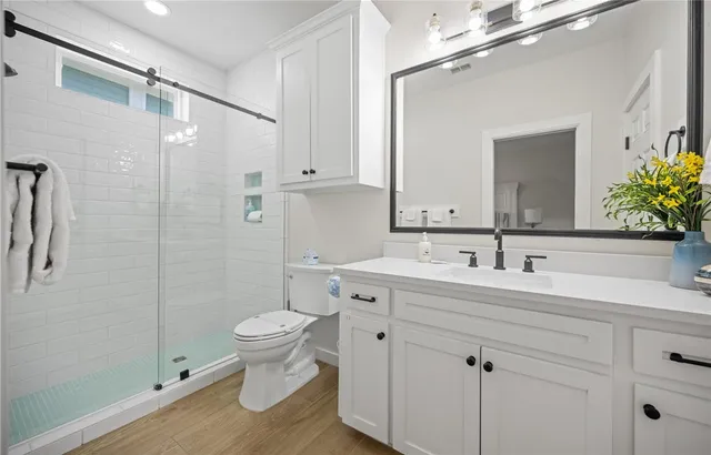 a bathroom with a sink and mirror with toilet