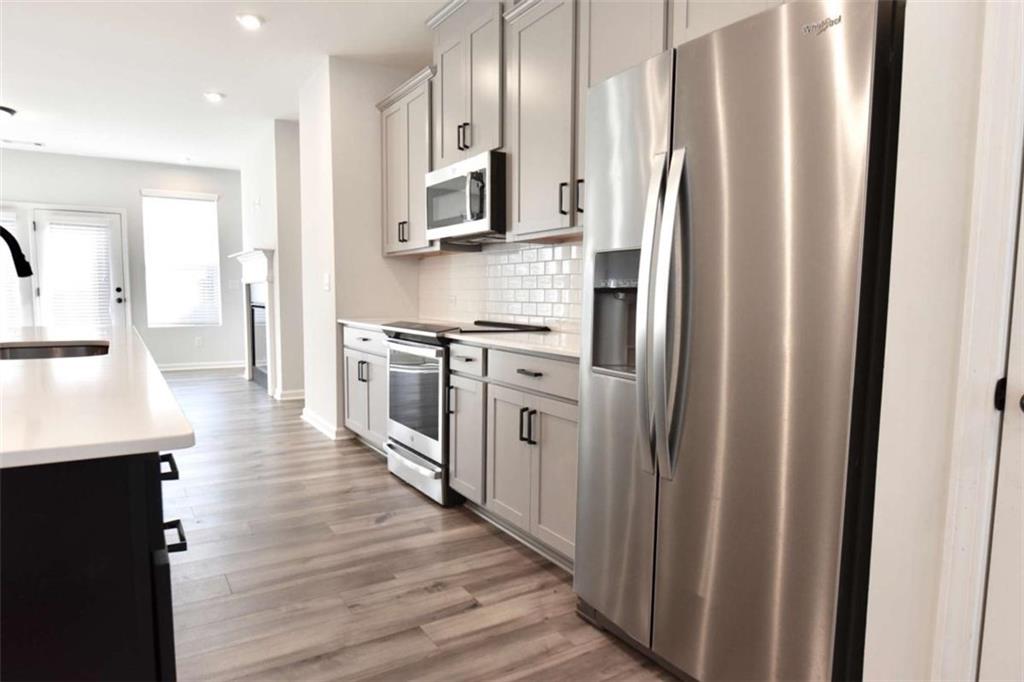 809 Cameron Trail Acworth, GA 30102 - Photo 13 of 38 a kitchen with stainless steel appliances a refrigerator a sink and wooden cabinets