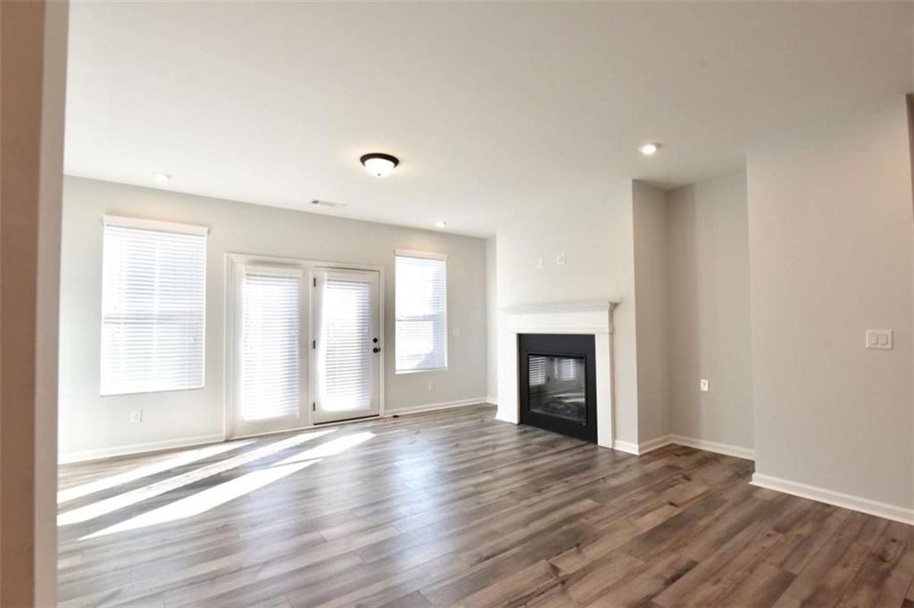 809 Cameron Trail Acworth, GA 30102 - Photo 8 of 38 an empty room with wooden floor fireplace and windows