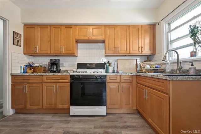 a kitchen with stainless steel appliances granite countertop a stove a sink dishwasher and a refrigerator