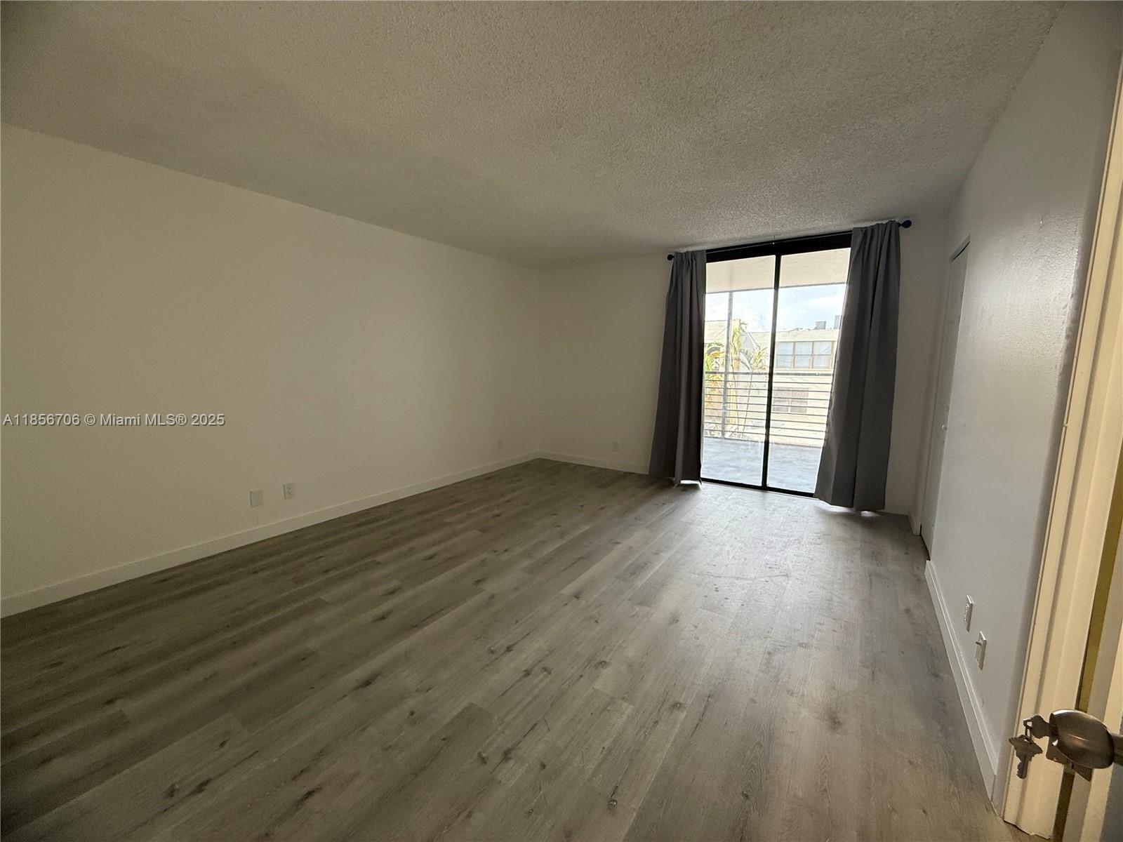 20200 West Country Club Drive, Unit PH14 Aventura, FL 33180 - Photo 12 of 15 a view of an empty room with wooden floor and a window