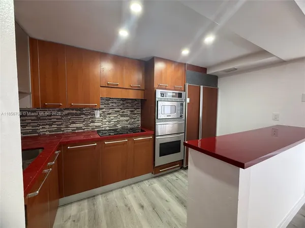 a kitchen with stainless steel appliances kitchen island granite countertop a refrigerator and a stove