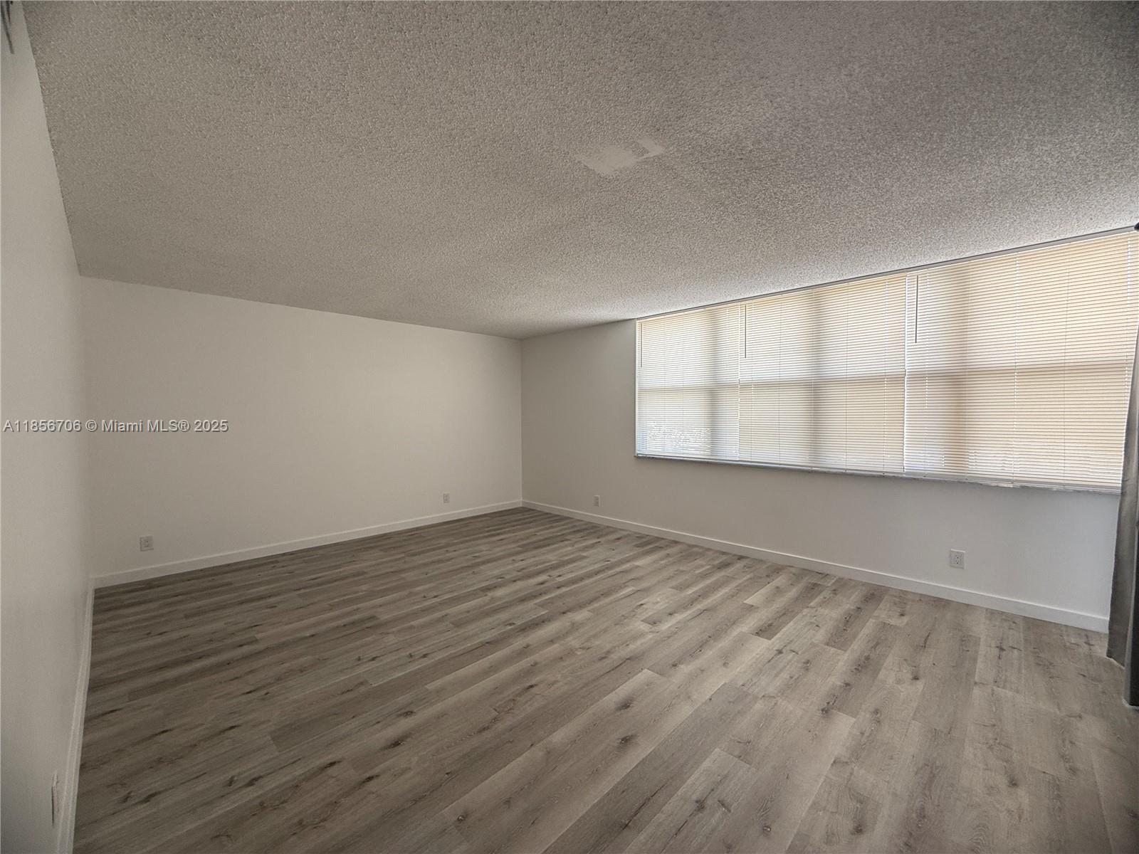20200 West Country Club Drive, Unit PH14 Aventura, FL 33180 - Photo 5 of 15 wooden floor in an empty room with a window