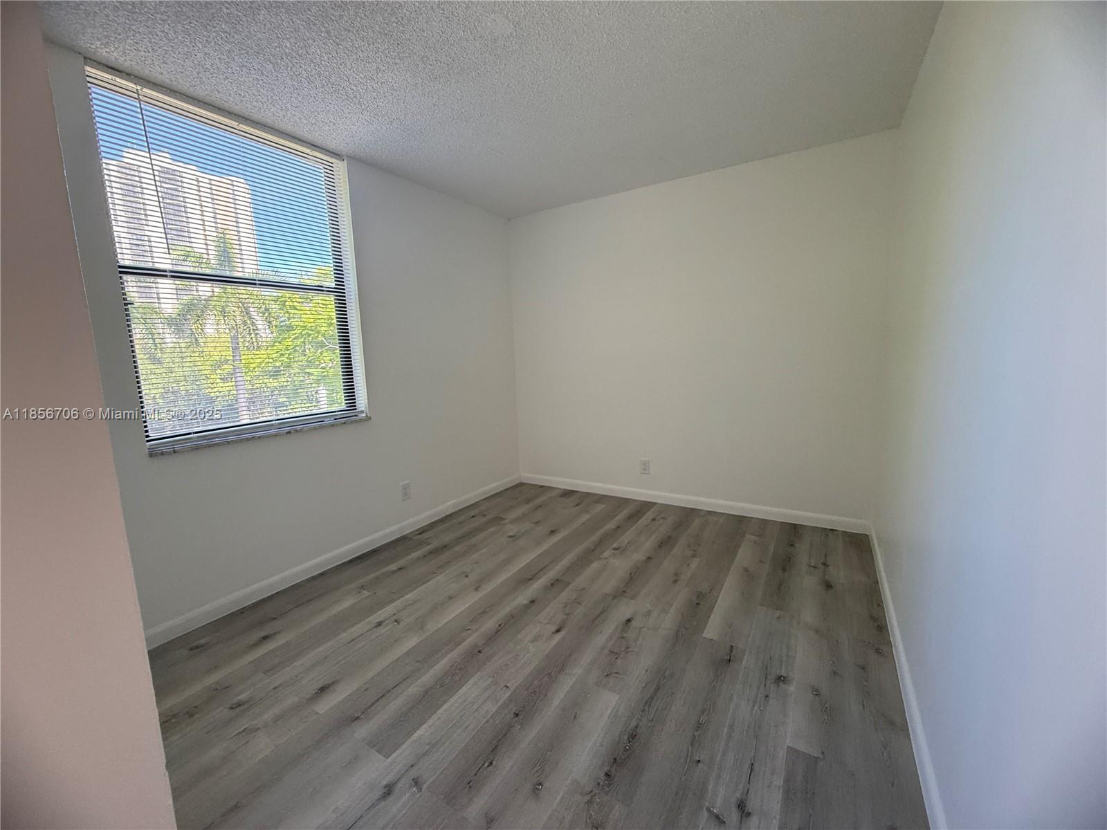 20200 West Country Club Drive, Unit PH14 Aventura, FL 33180 - Photo 7 of 15 an empty room with wooden floor and windows