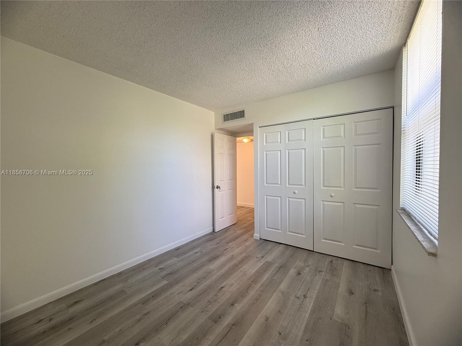 20200 West Country Club Drive, Unit PH14 Aventura, FL 33180 - Photo 8 of 15 an empty room with wooden floor and sliding door