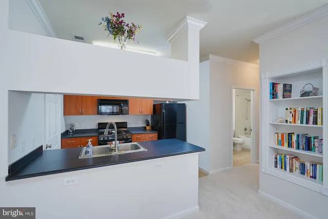 a kitchen with stainless steel appliances granite countertop a refrigerator a sink and a stove