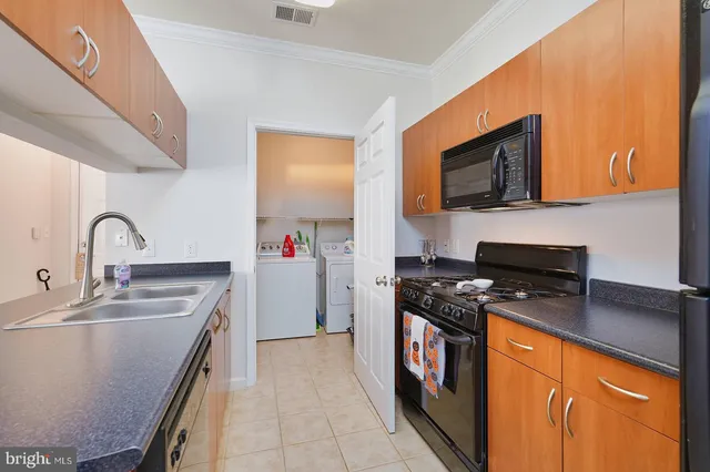a kitchen with stainless steel appliances granite countertop a sink a refrigerator and a counter space