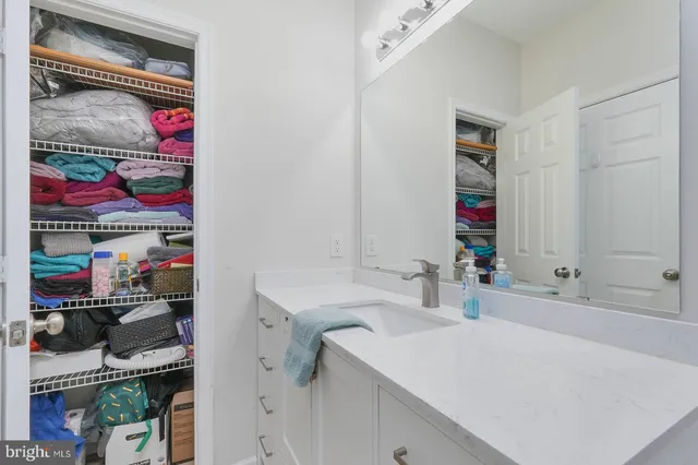 a bathroom with a granite countertop sink a toilet and a mirror