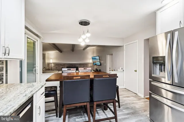 a kitchen with stainless steel appliances a dining table and chairs
