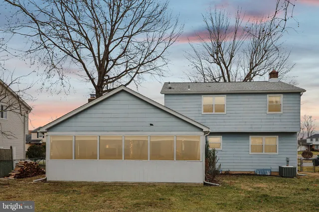 a front view of house with yard and trees in the background