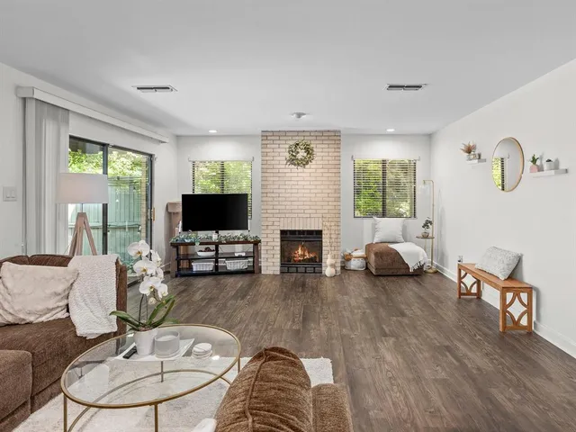 a living room with furniture a flat screen tv and a fireplace