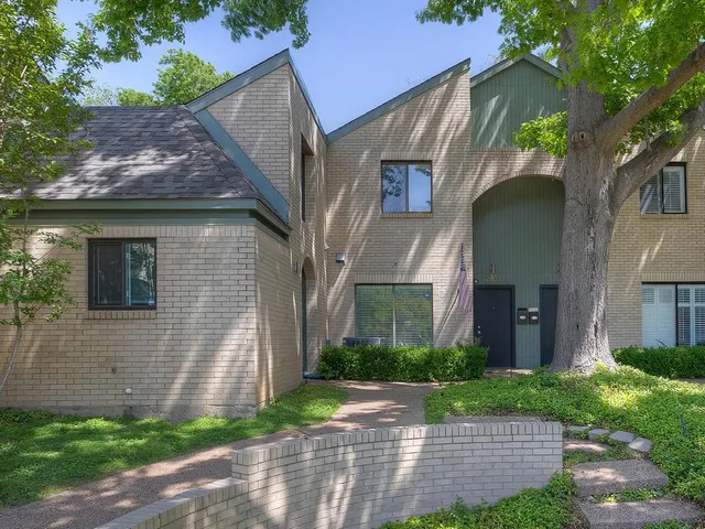 a front view of a house with a yard and potted plants