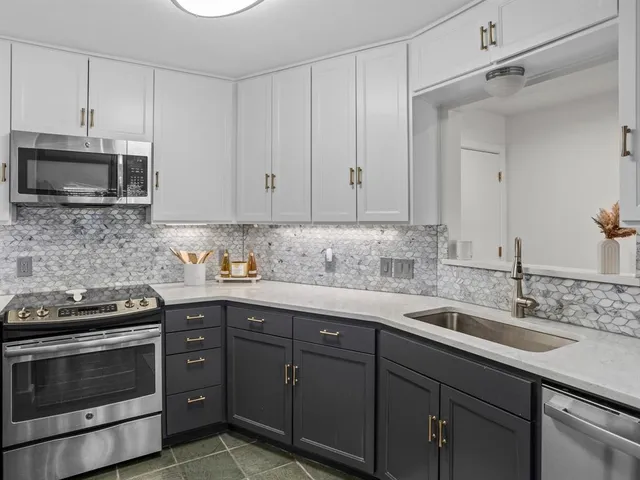 a kitchen with stainless steel appliances granite countertop a sink stove and microwave