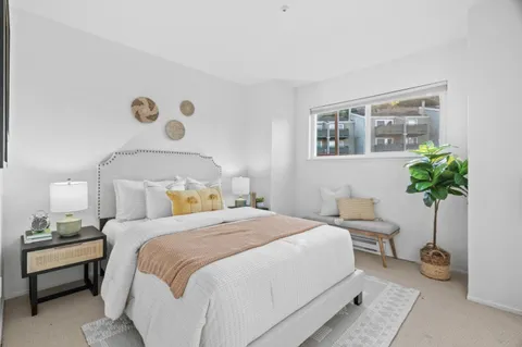 a bedroom with a bed and a potted plant