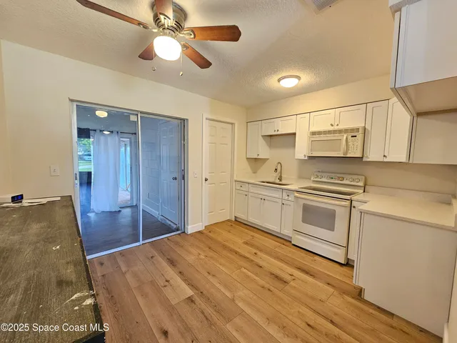 a kitchen with a stove cabinets and wooden floor