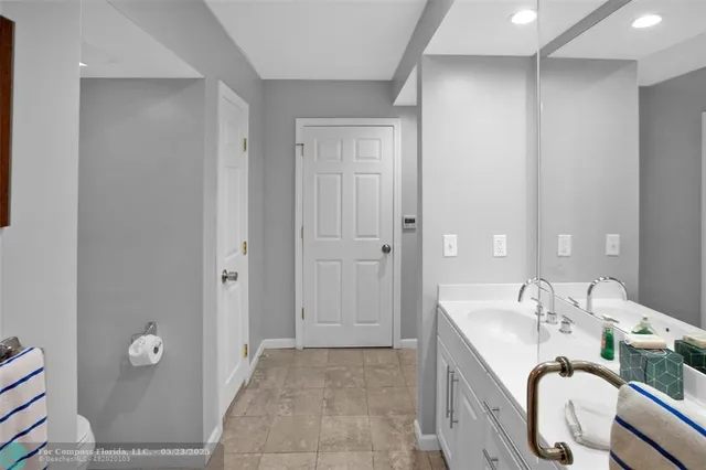 a bathroom with a granite countertop sink a mirror and a bathtub
