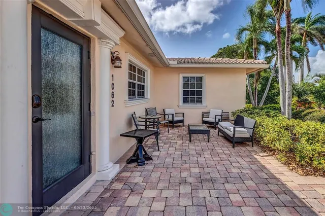 a view of a patio with chairs and potted plants