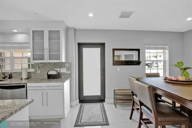 a kitchen with a sink a stove cabinets and a dining table